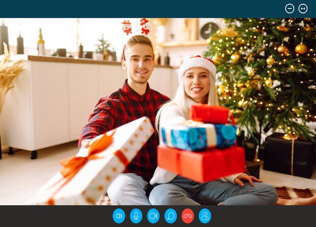 Captura de tela retrato casal sorridente com presente de Natal sentado em casa Reunião virtual Festa online