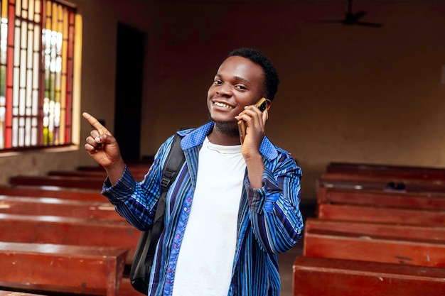 Captura de um estudante africano apontando para o espaço de cópia contra um fundo de sala de aula