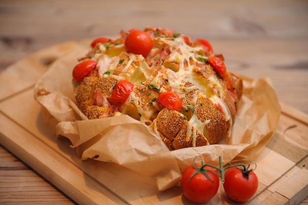 Captura de um pão assado feito com molho e tomate em um fundo desfocado