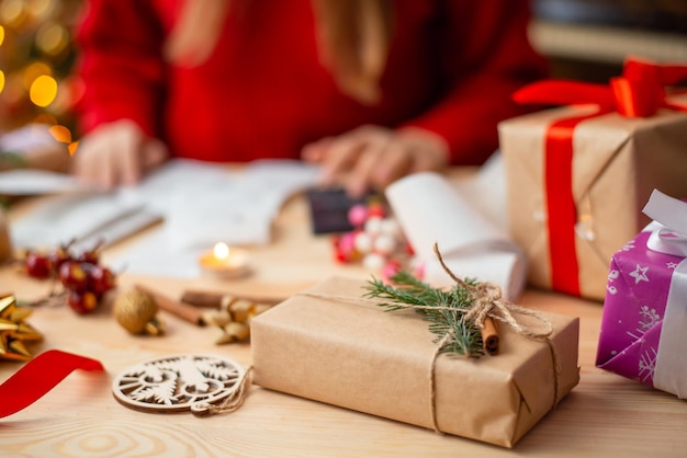 Captura de um presente feito à mão no fundo da menina, verificando se todos os presentes estão prontos, prepare-se para enviá-los para amigos e parentes, preparativos para presentes de Natal