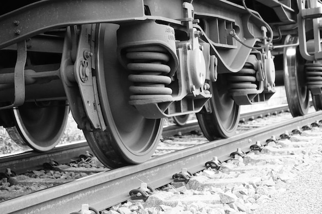 Captura em escala de cinza dos trilhos de uma ferrovia com um trem em movimento