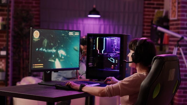 Captura de mano de una jugadora celebrando ganar el primer lugar en un juego espacial de acción mientras el hombre juega a un tirador en primera persona en realidad virtual. Par de simulación de juegos en línea usando PC y gafas vr.