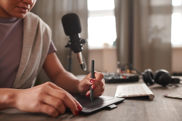 Captura média de uma artista digital feminina irreconhecível sentada à mesa desenhando algo usando