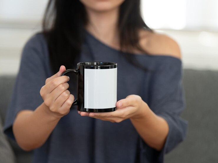 Captura el momento acogedor con una chica con una elegante camisa gris saboreando una taza caliente de café