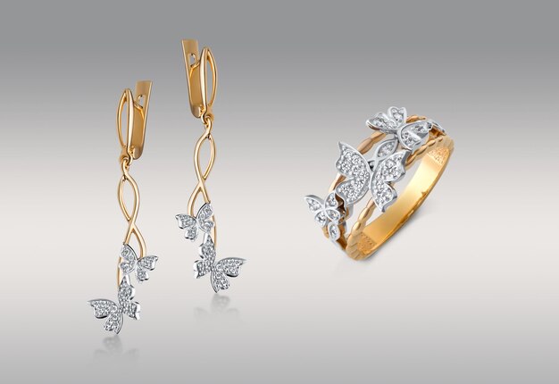 Captura de pantalla de los aretes de oro y el anillo con mariposas de diamantes aisladas en el fondo blanco