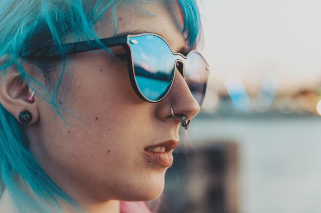 Captura de pantalla de una atractiva joven de pelo azul con gafas de sol