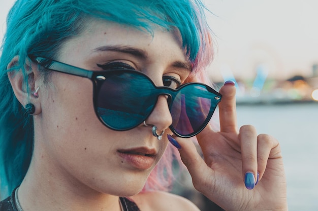 Captura de pantalla de una atractiva joven de pelo azul con gafas de sol