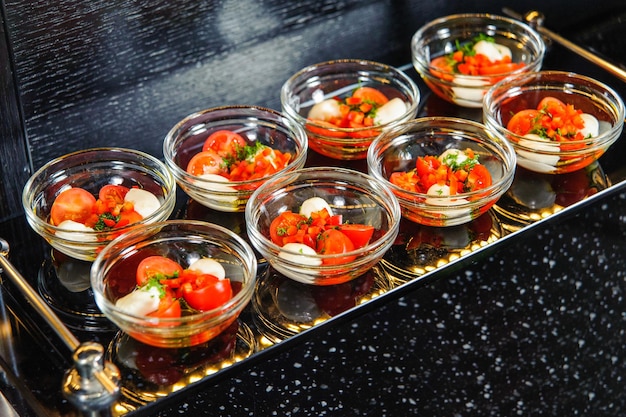 Captura de pantalla de un conjunto de ensaladas de tomate en tazones pequeños en una bandeja