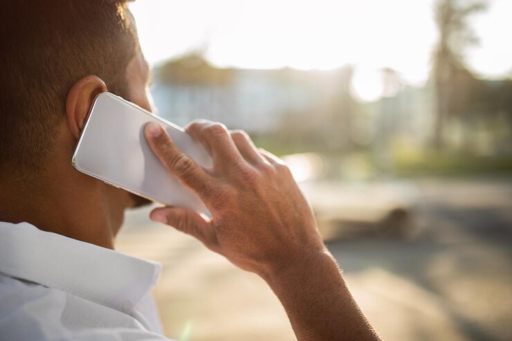 Foto captura de pantalla de un hombre de negocios hablando por celular al aire libre teniendo una conversación móvil por teléfono