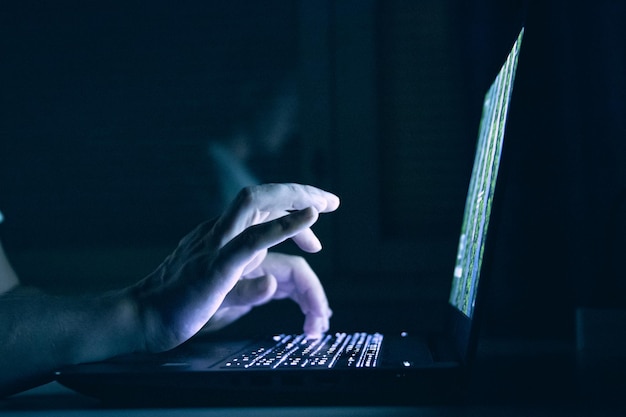 Captura de pantalla de un hombre que trabaja en su computadora en un cuarto oscuro