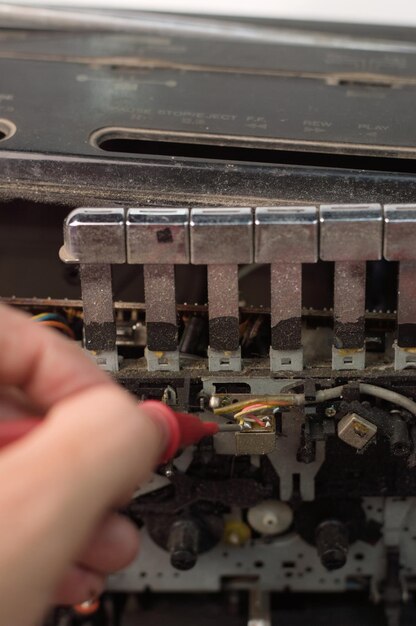 Foto captura de pantalla de un técnico que mide el voltaje en la cabeza del lector de cintas de casete