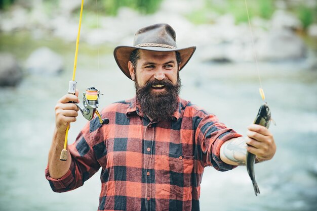 La captura de un pez grande con una caña de pescar peces en el anzuelo pesca con mosca sosteniendo la pesca de trucha marrón con ...