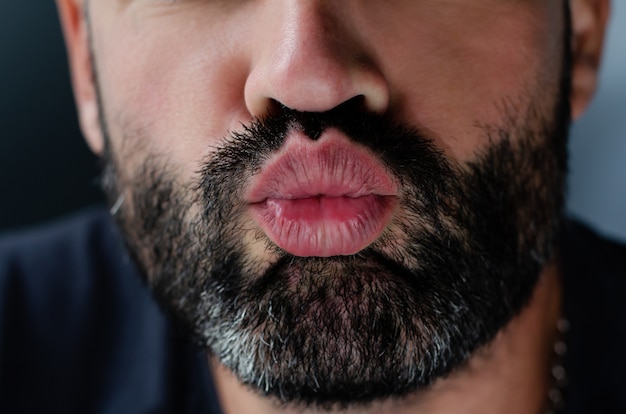 Foto captura recortada de brutal hombre sin afeitar dando un beso. de cerca.