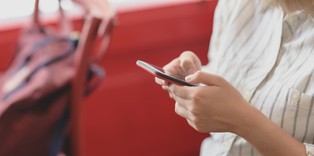 Captura recortada de una joven empresaria sosteniendo un teléfono inteligente mientras trabajaba en su proyecto