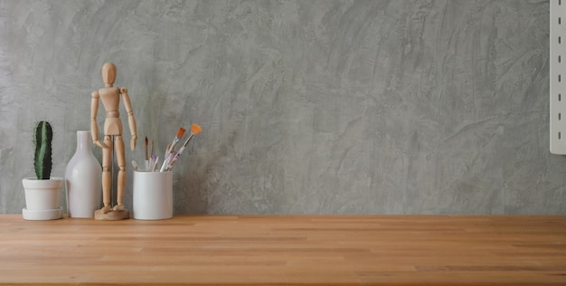 Captura recortada del lugar de trabajo de moda con material de oficina en mesa de madera y pared gris