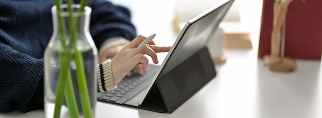 Captura recortada de mujer independiente leyendo información en tableta digital