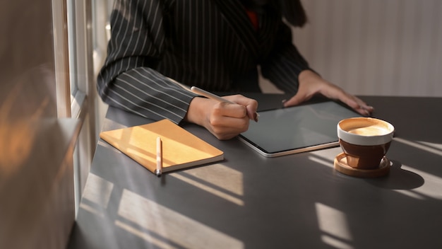 Foto captura recortada de mujer usando tableta digital en lugar de trabajo cómodo