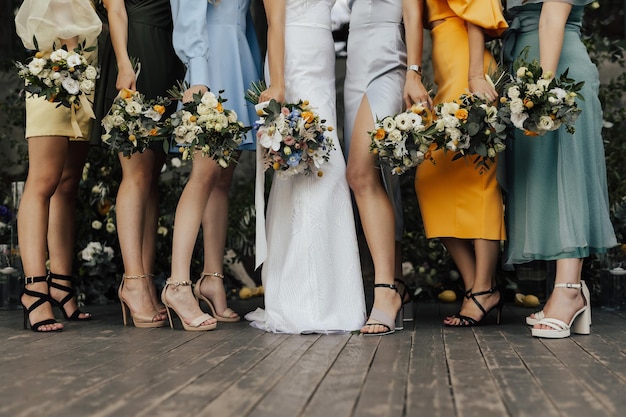 Captura recortada de las piernas de la novia y sus amigas con vestidos coloridos