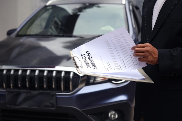 Foto captura recortada de ventas de alquiler de automóviles con documentos de alquiler en el contexto del automóvil.