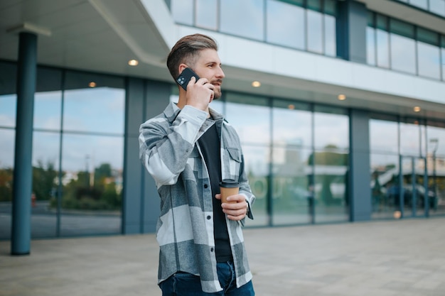 Capturado en el ciberespacio un chico guapo charlando por su teléfono móvil en un entorno urbano al aire libre, el arte