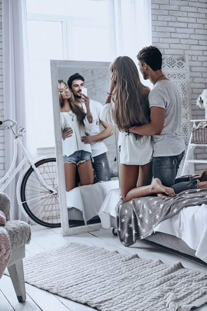 Capturando el amor. Vista trasera de los jóvenes hablando selfie y sonriendo