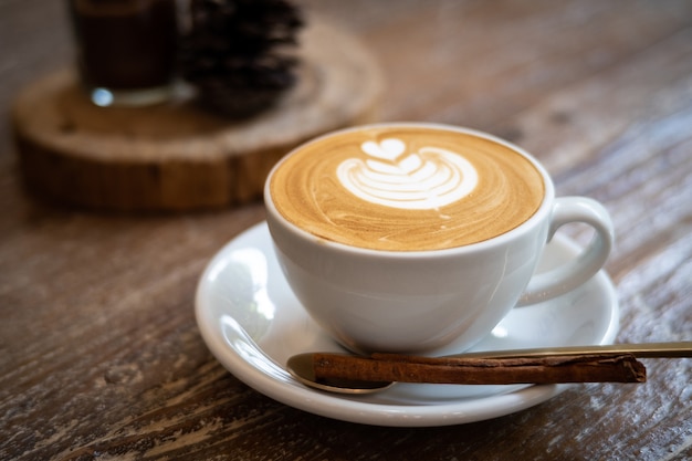 Capuchino con arte del latte en fondo de madera. Hermosa espuma