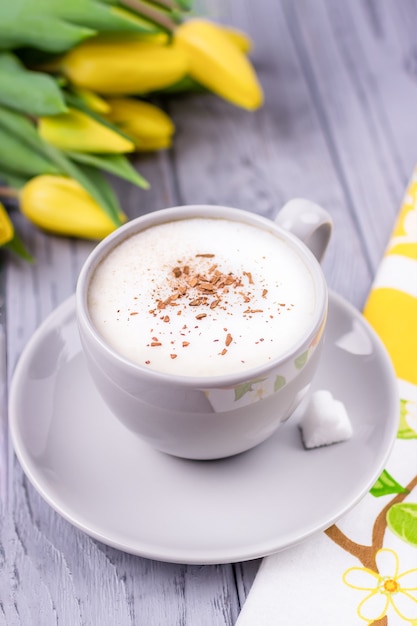 Capuchino de café con canela de Ceilán y tulipanes amarillos