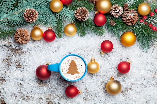 El capuchino con forma del árbol de navidad y la rama del pino en fondo artificial.