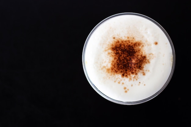 Capuchino de hielo. Vista superior de espuma de leche y cobertura de canela en polvo. Bebida refrescante.