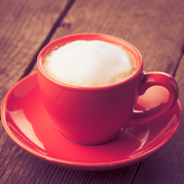 Capuchino o café en taza roja - estilo vintage