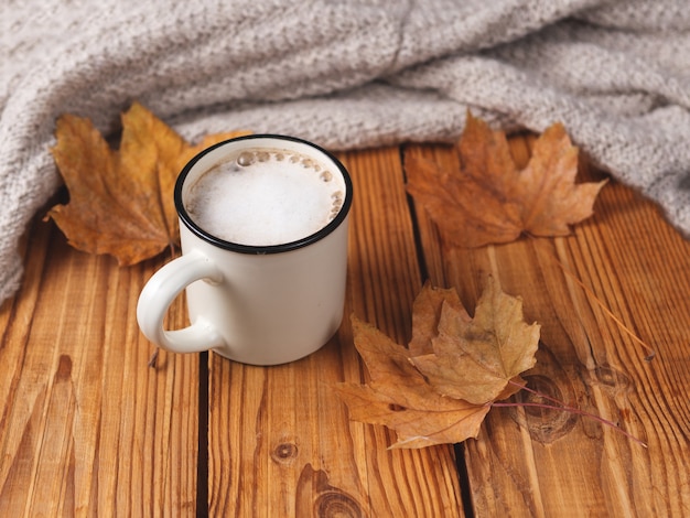 Capuchino de otoño con canela en mesa de madera