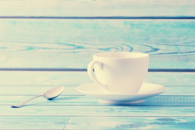 capuchino en una taza blanca sobre mesa azul