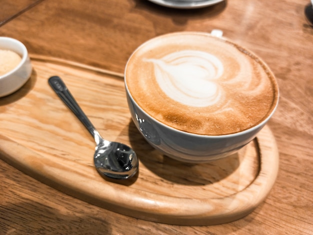 Capuchino en una taza de cerámica en una bandeja de madera