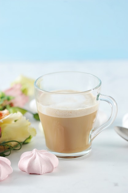 Capuchino en taza transparente con flores y malvaviscos