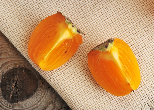 Caqui em fatias de laranja sobre tela