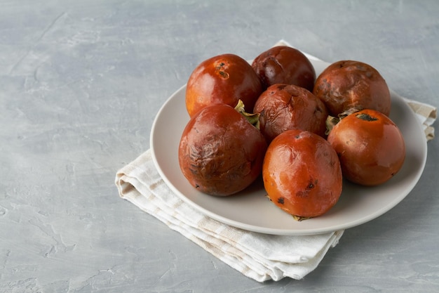 Caqui de frutas feo sobre fondo gris comida fea cero desperdicio