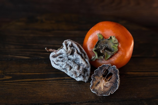 Caqui seco e caqui fresco em um fundo de madeira Dieta saudável Dieta saudável