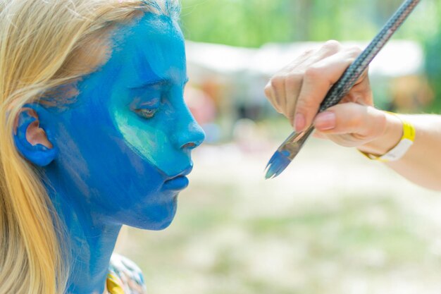 La cara de un adolescente está pintada con un aquagrim.