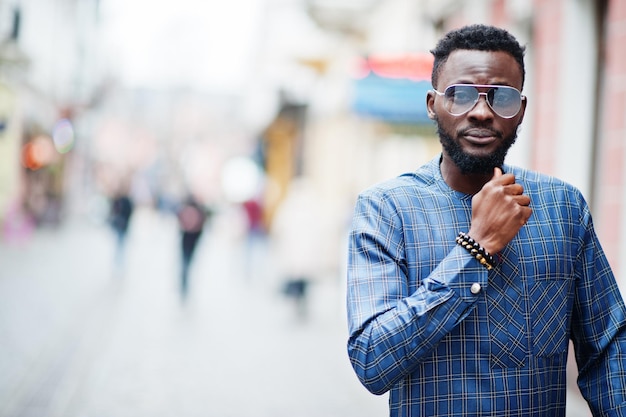 Cara africano em traje azul autêntico, óculos. Homem nigeriano elegante.