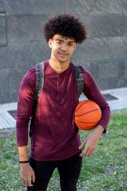 Cara Africano na universidade com uma bola de basquete