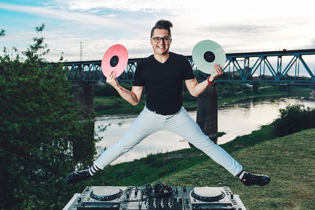 Foto cara alegre engraçado pulando com discos de vinil nas mãos