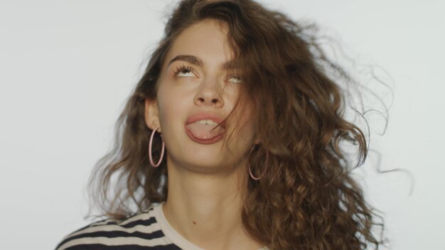 Cara alegre de mujer hermosa sobre fondo blanco Emoción juguetona femenina