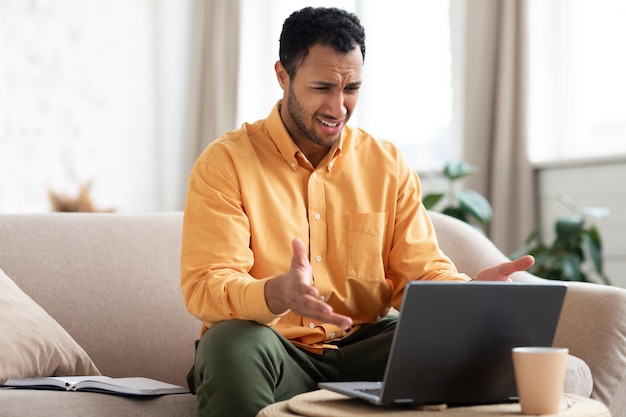 Cara árabe confuso usando laptop olhando para a tela