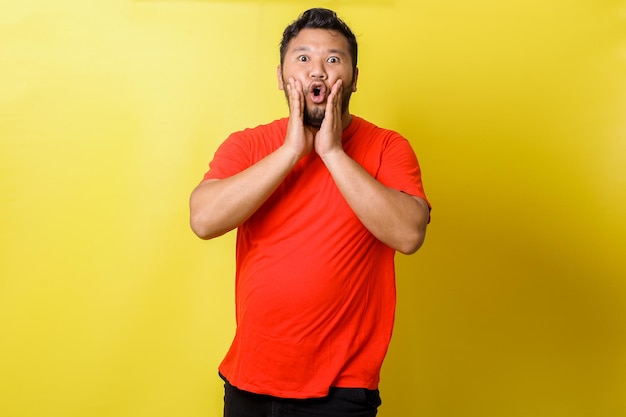 Cara asiático gordo gritando com câmera isolada em fundo amarelo