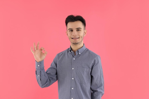 Cara atraente em uma camisa em fundo rosa