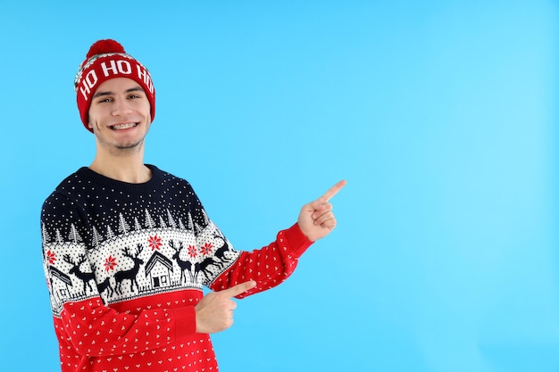 Cara atraente na camisola de Natal em fundo azul