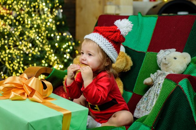 Cara de bebé lindo con sombrero de santa cerca del árbol de navidad feliz infancia niño año nuevo niños cristo ...