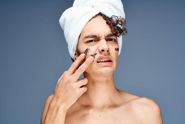 Cara bonito com uma toalha na cabeça, ombros nus, cosméticos, pele limpa