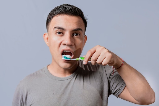 Cara bonito escovando os dentes isolado Close-up de homem bonito escovando os dentes Conceito de escovação e higiene dental Close-up de pessoas escovando os dentes no fundo isolado