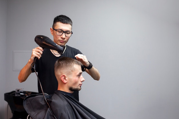 Cara bonito tem um corte de cabelo em uma barbearia